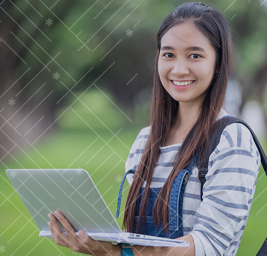 High school girl in overalls holding computer